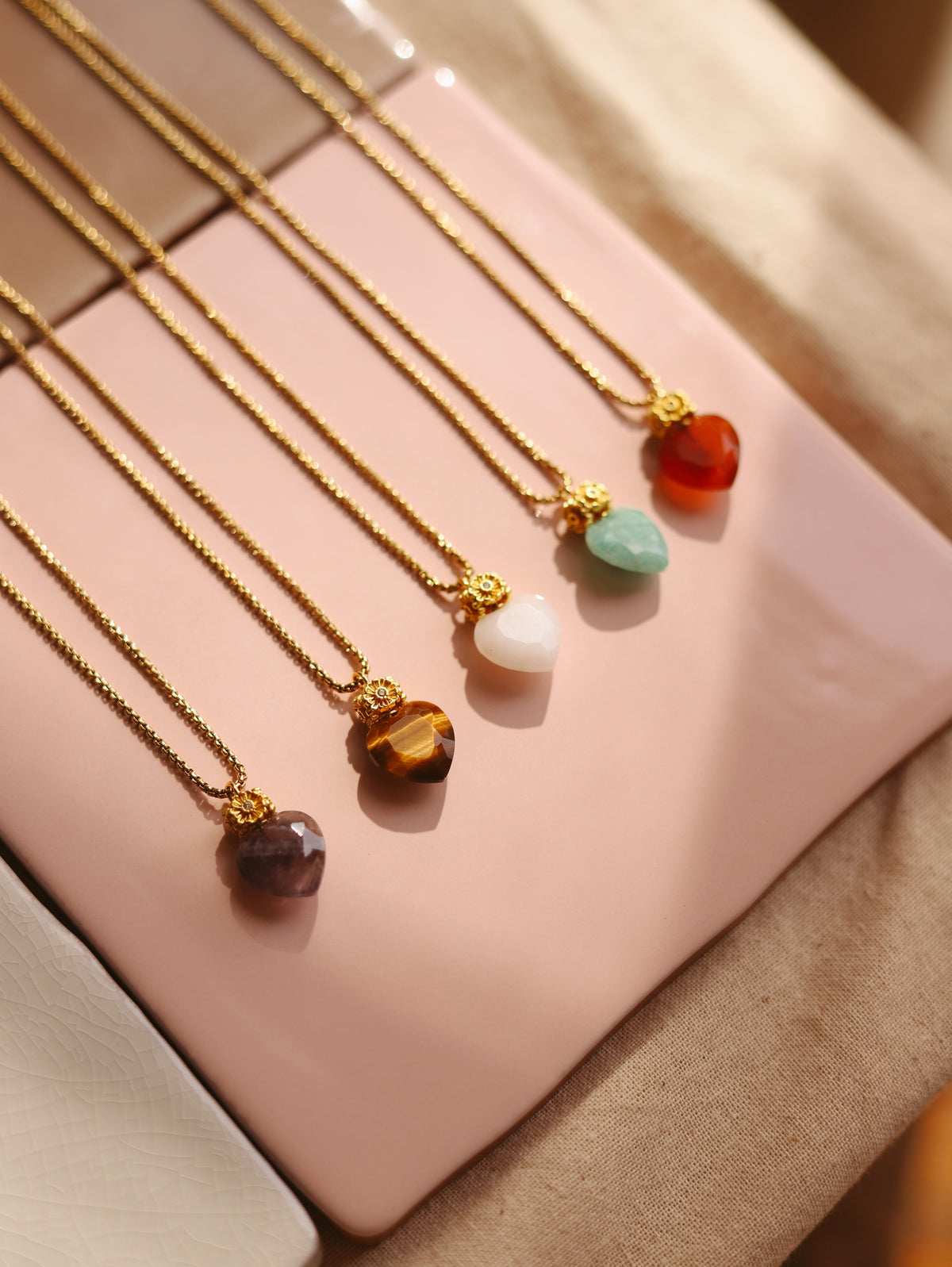 Colares de corrente dourada com pendentes em forma de coração em pedras naturais: ametista, olho de tigre, pedra branca, amazonite e cornalina