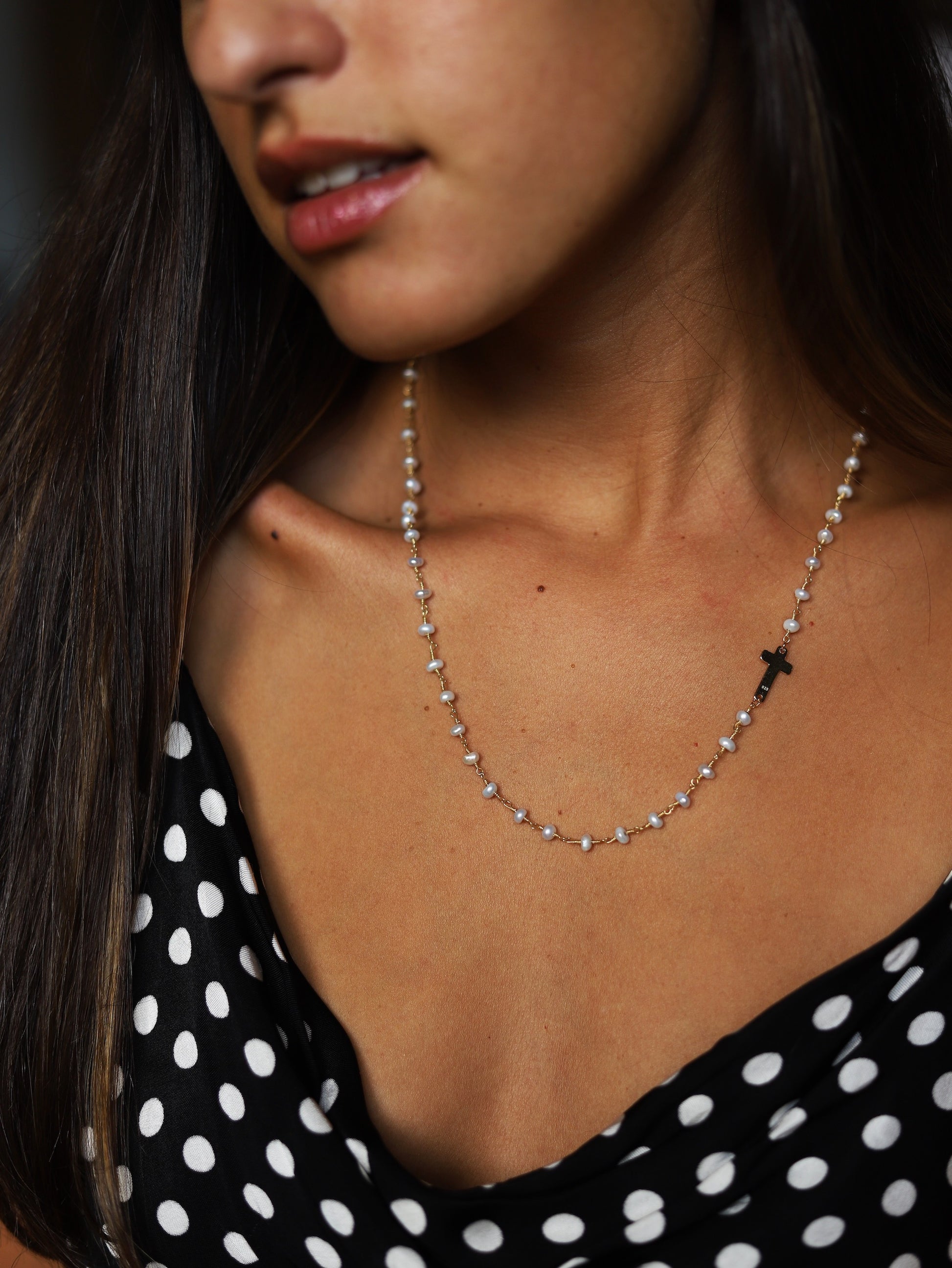 Verona Cruz necklace on the side