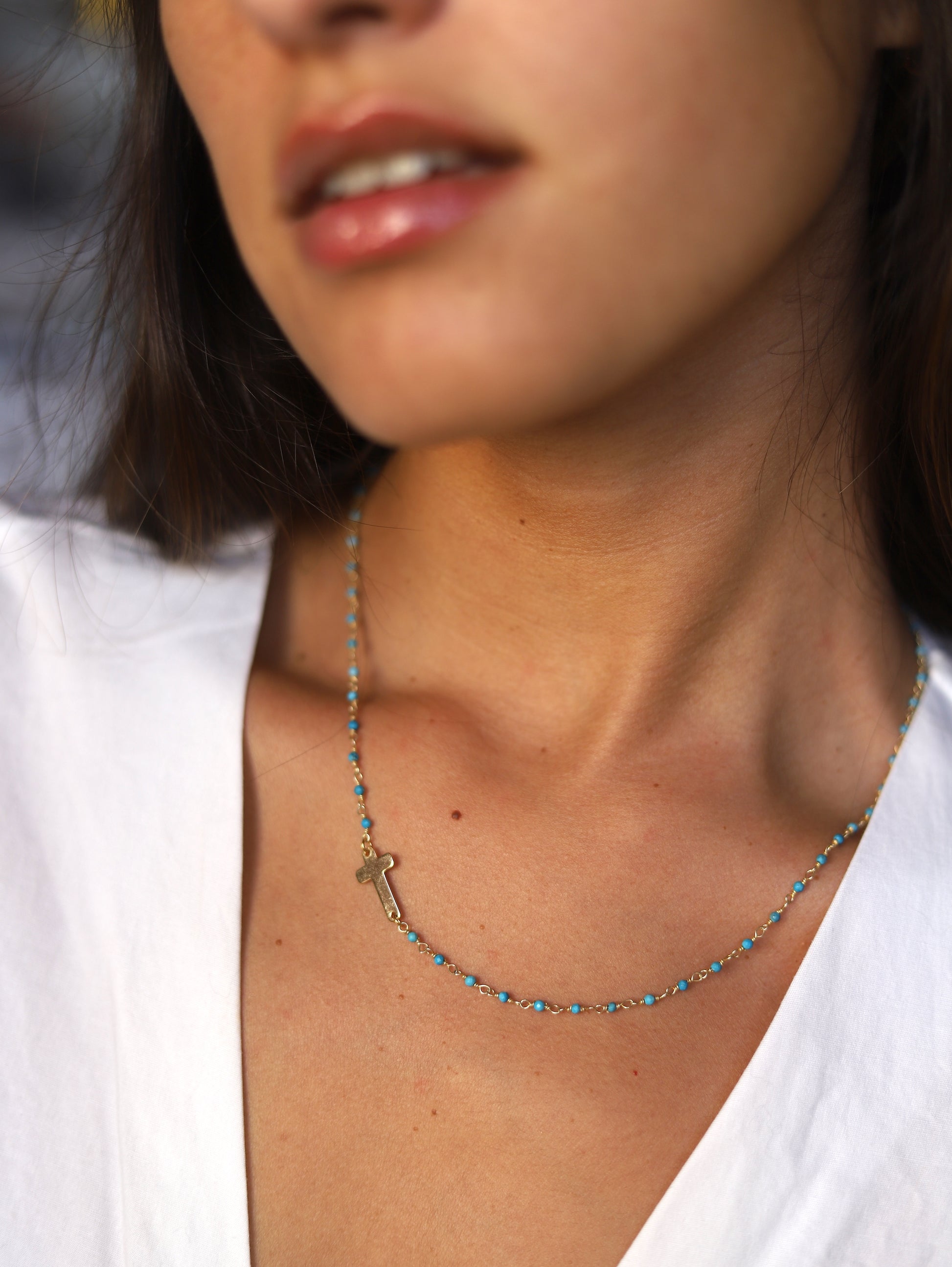 Verona Cruz necklace on the side